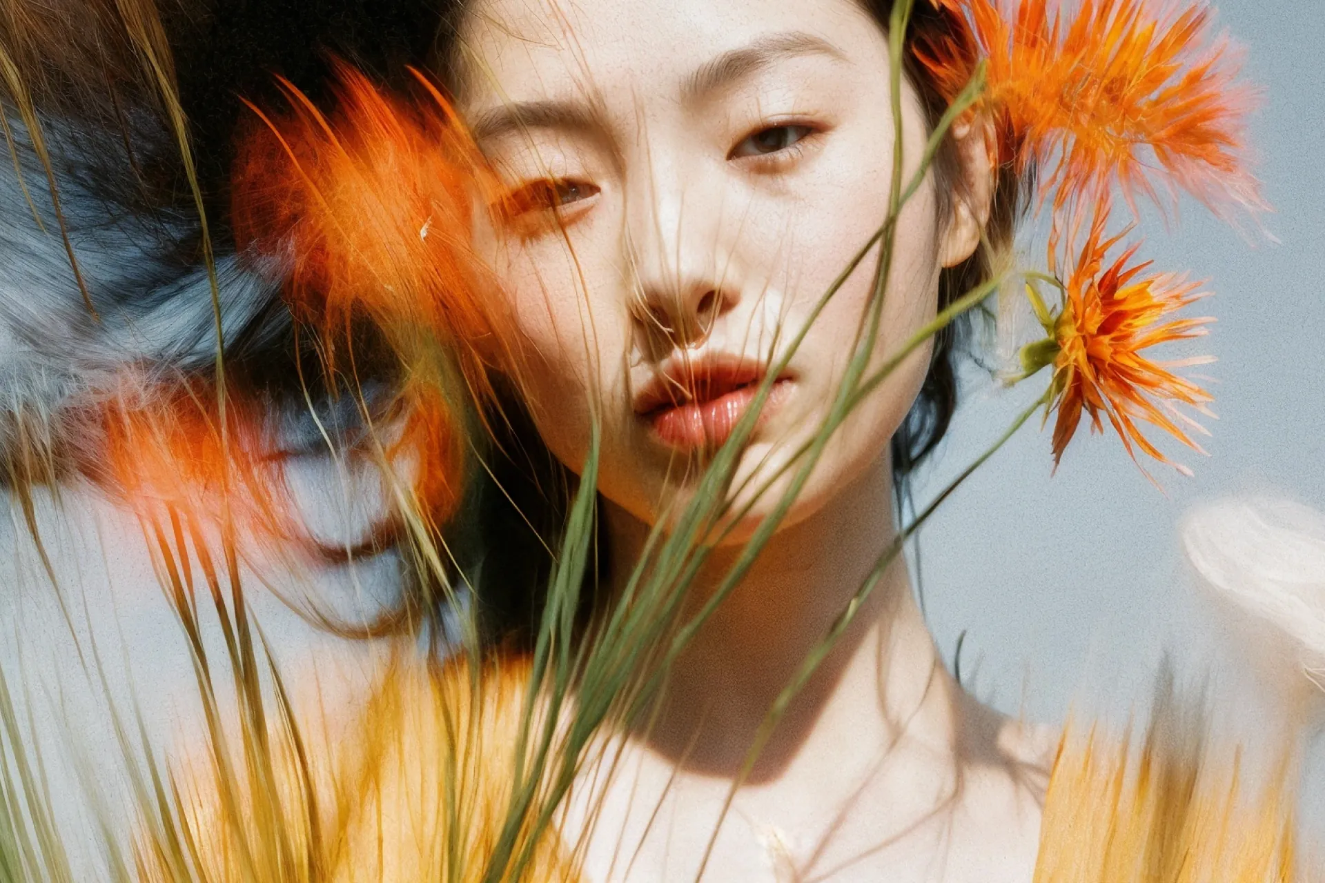 Woman's face framed by orange wildflowers