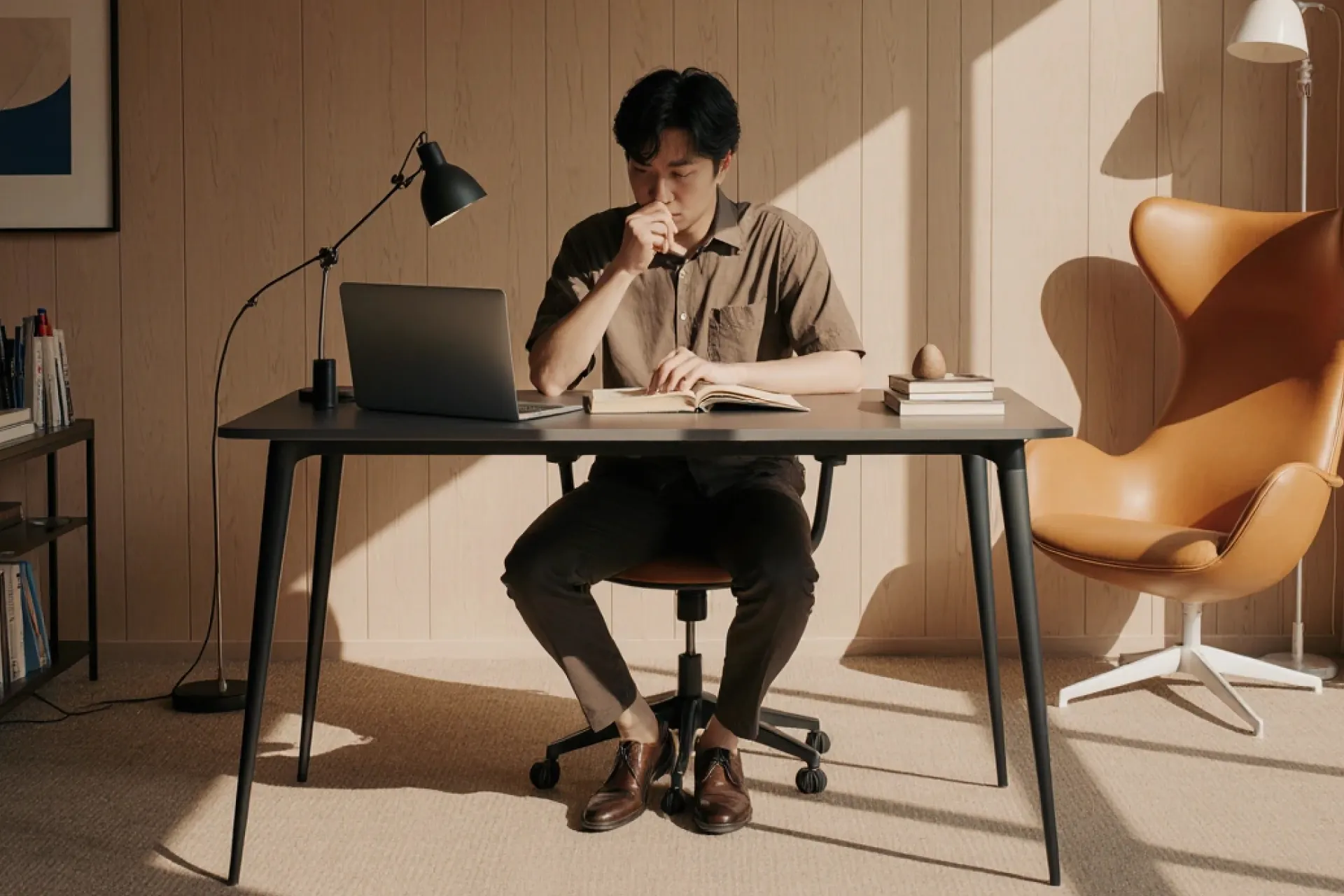Man reading notes at a desk in a home office