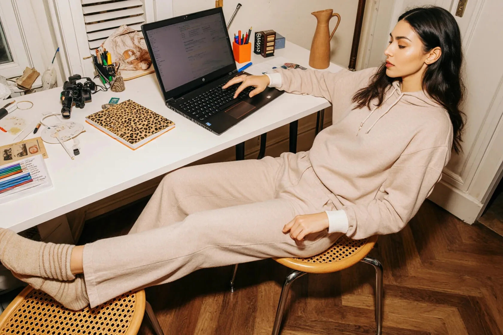 Woman working on a laptop with her feet up in a home office