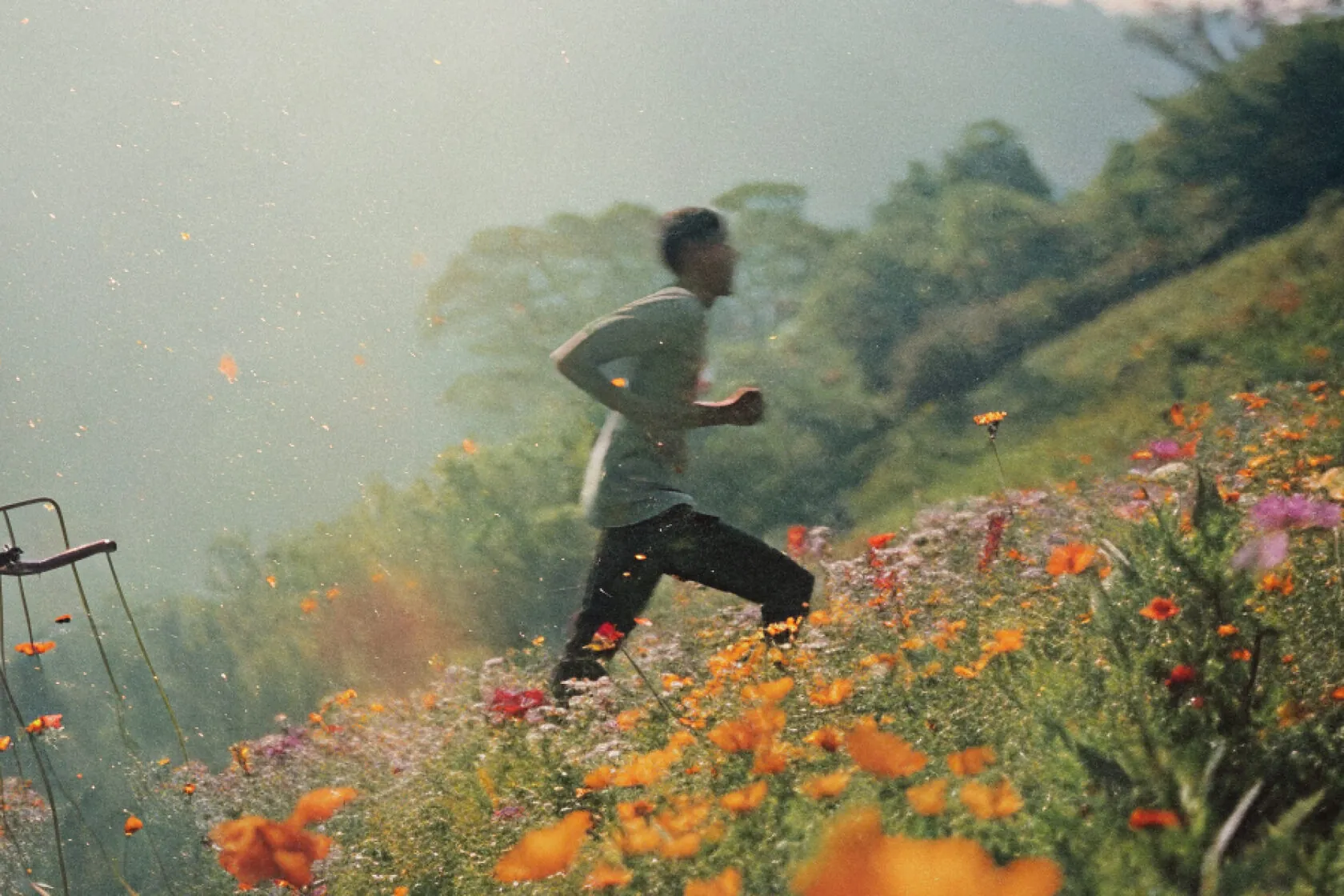 Man running through a hillside of wildflowers